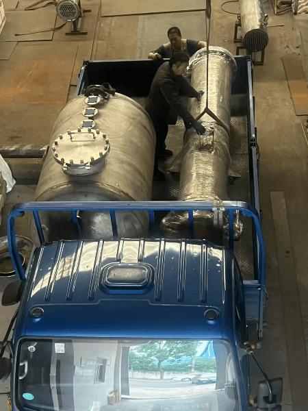 Technicians securing the exchanger on a truck bed for safe transport. Technicians securing the exchanger on a truck bed for safe transport.