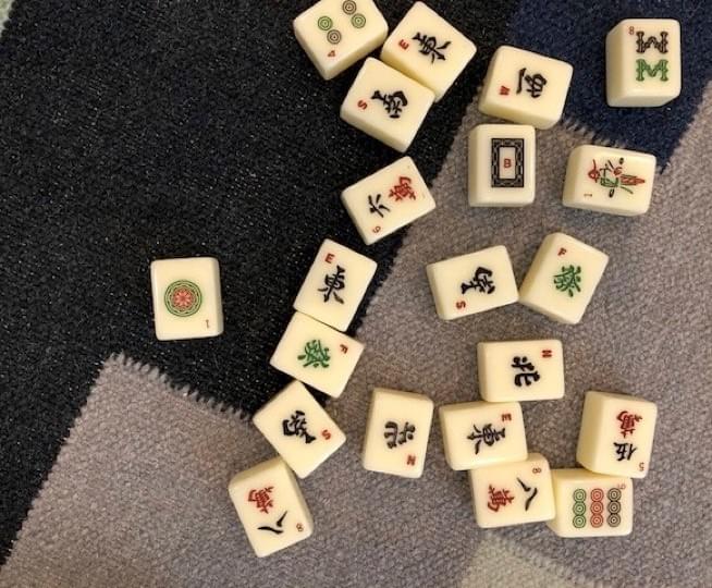 majiang tiles scattered face-up on a rug majiang tiles scattered face-up on a rug