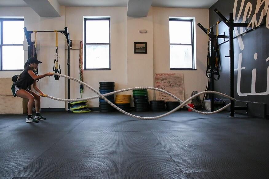 A photo of a woman using battle ropes while exercising during a workout, photo featured in the blog post "A Love Letter to Battle Ropes" by The Purple Dog Vegan A photo of a woman using battle ropes while exercising during a workout, photo featured in the blog post "A Love Letter to Battle Ropes" by The Purple Dog Vegan