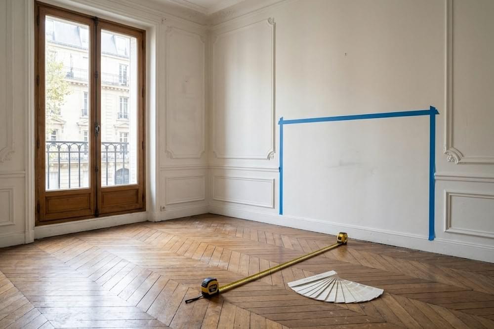 Mur de tête de lit préparé au ruban de masquage avec nuancier et mètre ruban au sol Mur de tête de lit préparé au ruban de masquage avec nuancier et mètre ruban au sol