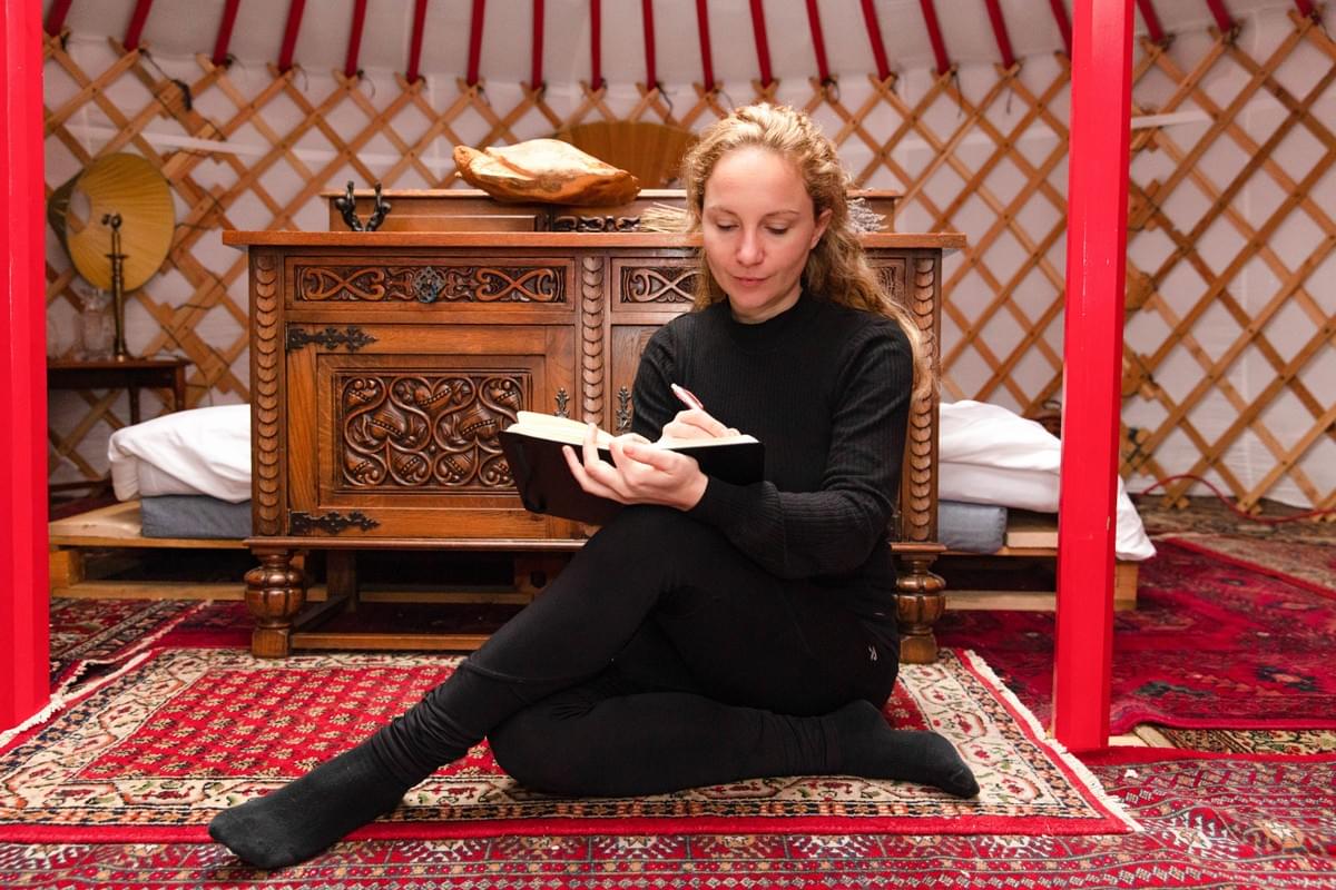 Lara in een reflectief moment, schrijvend in een warme en persoonlijke setting Lara in een reflectief moment, schrijvend in een warme en persoonlijke setting