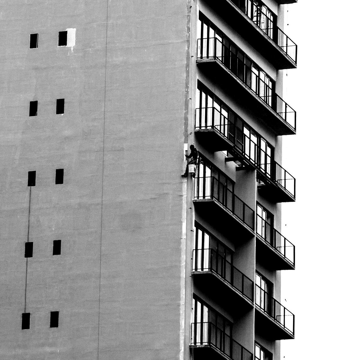 A black and white balcony with a window cleaner hanging from the corner A black and white balcony with a window cleaner hanging from the corner