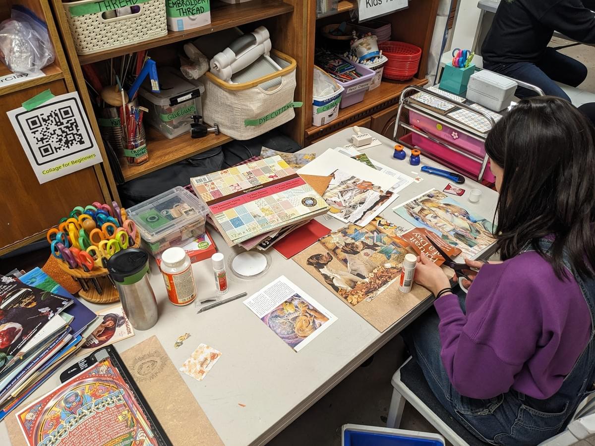 Woman seen from the back cutting out papers with designs on them for a scrapbook or decoupage project. Woman seen from the back cutting out papers with designs on them for a scrapbook or decoupage project.