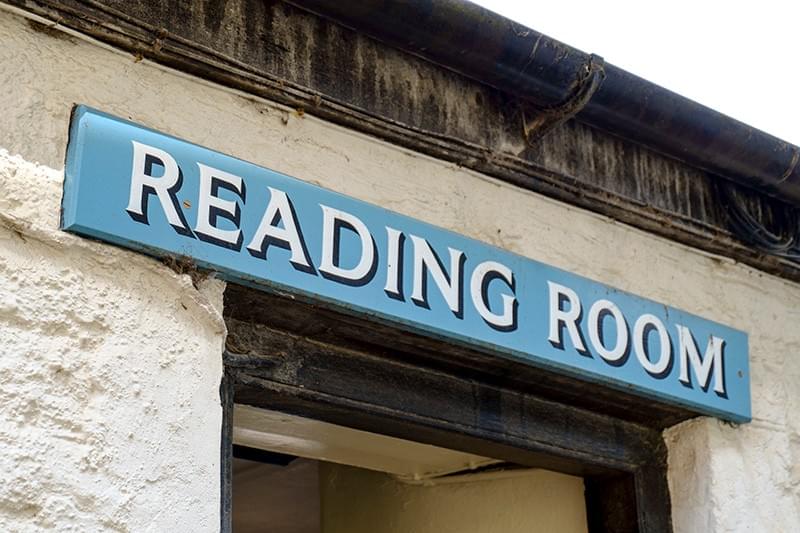 Photobooks By Women Reading Room sign above the entrance door to a hall Photobooks By Women Reading Room sign above the entrance door to a hall
