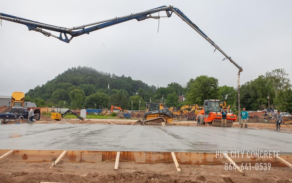 crew and boom truck operator pouring wet concrete for large commercial slab crew and boom truck operator pouring wet concrete for large commercial slab