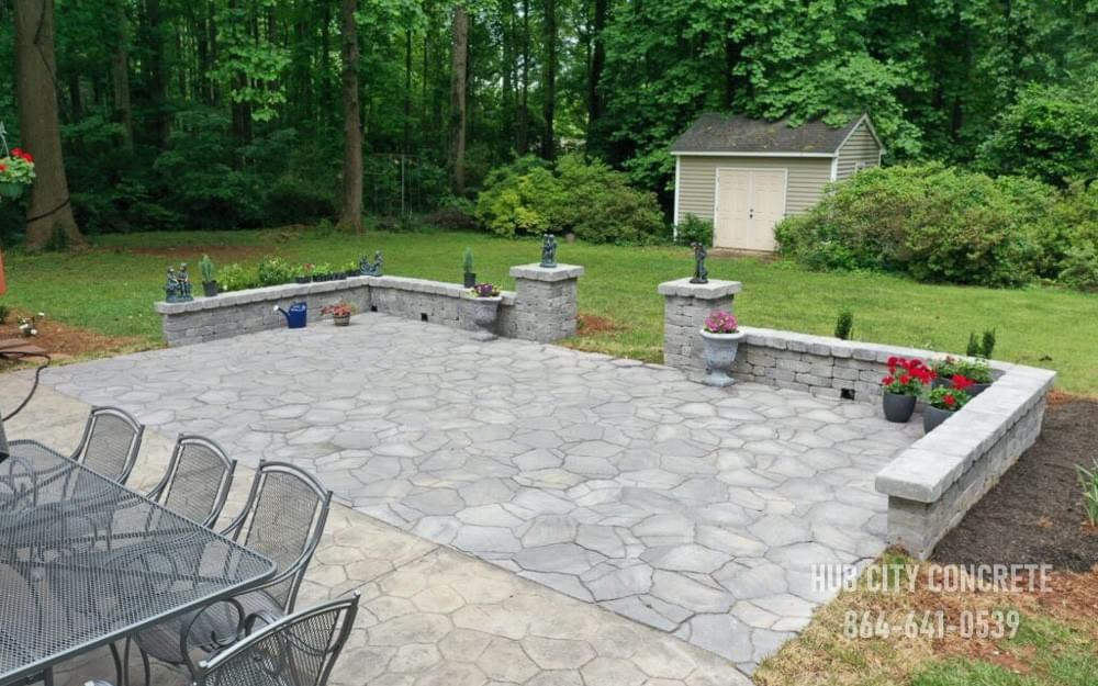 residential patio addition in backyard with stamped pattern and stone wall residential patio addition in backyard with stamped pattern and stone wall