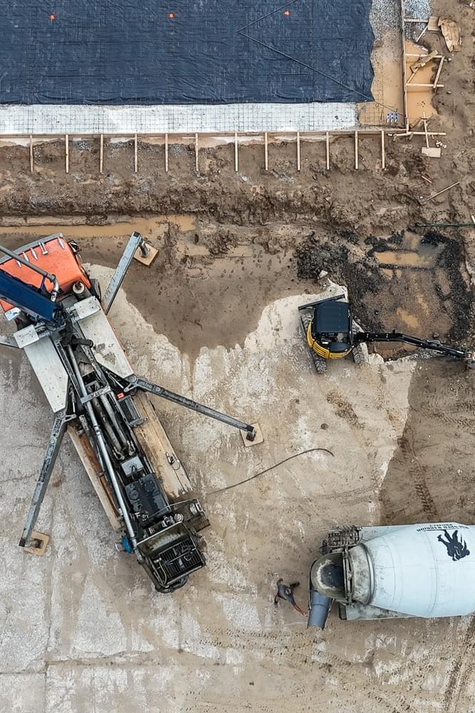aerial view of commercial worksite in Spartanburg SC with boom truck cement truck and excavator aerial view of commercial worksite in Spartanburg SC with boom truck cement truck and excavator
