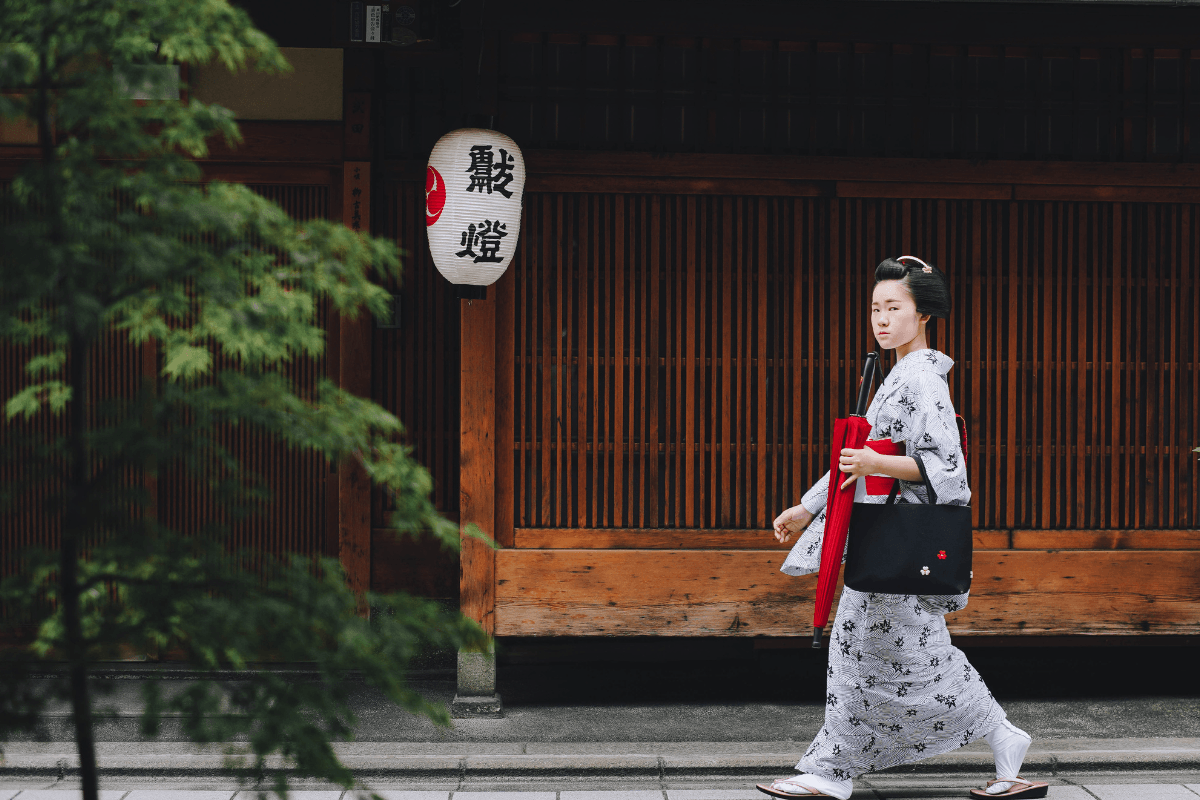 Woman in traditional kimono walking along a quiet street in Japan, representing everyday cultural life beyond major cities Woman in traditional kimono walking along a quiet street in Japan, representing everyday cultural life beyond major cities