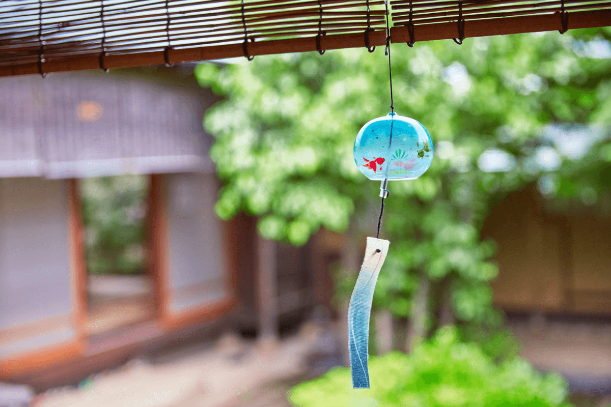 Traditional Japanese wind chime hanging in a quiet courtyard, representing thoughtful and authentic local travel in Japan Traditional Japanese wind chime hanging in a quiet courtyard, representing thoughtful and authentic local travel in Japan