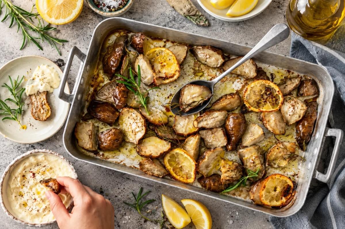 Sheet pan of roasted Jerusalem artichokes with lemon slices, fresh rosemary, and a side of creamy dipping sauce. Sheet pan of roasted Jerusalem artichokes with lemon slices, fresh rosemary, and a side of creamy dipping sauce.