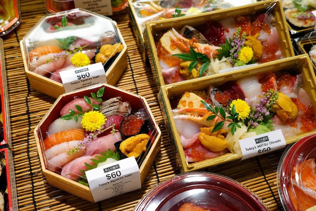 Close-up of a chirashi bento box filled with raw fish, sea urchin, crab claw, and salmon roe. Close-up of a chirashi bento box filled with raw fish, sea urchin, crab claw, and salmon roe.