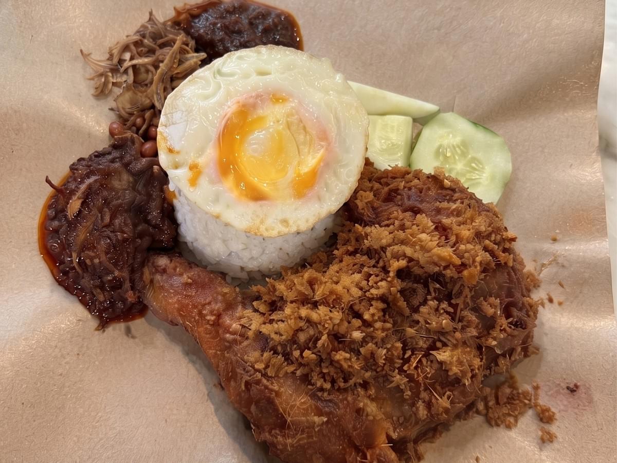 Authentic Nasi Lemak with crispy Ayam Goreng Berempah from Dickson Nasi Lemak, served with sambal, fried egg, anchovies, peanuts, and cucumber. Authentic Nasi Lemak with crispy Ayam Goreng Berempah from Dickson Nasi Lemak, served with sambal, fried egg, anchovies, peanuts, and cucumber.