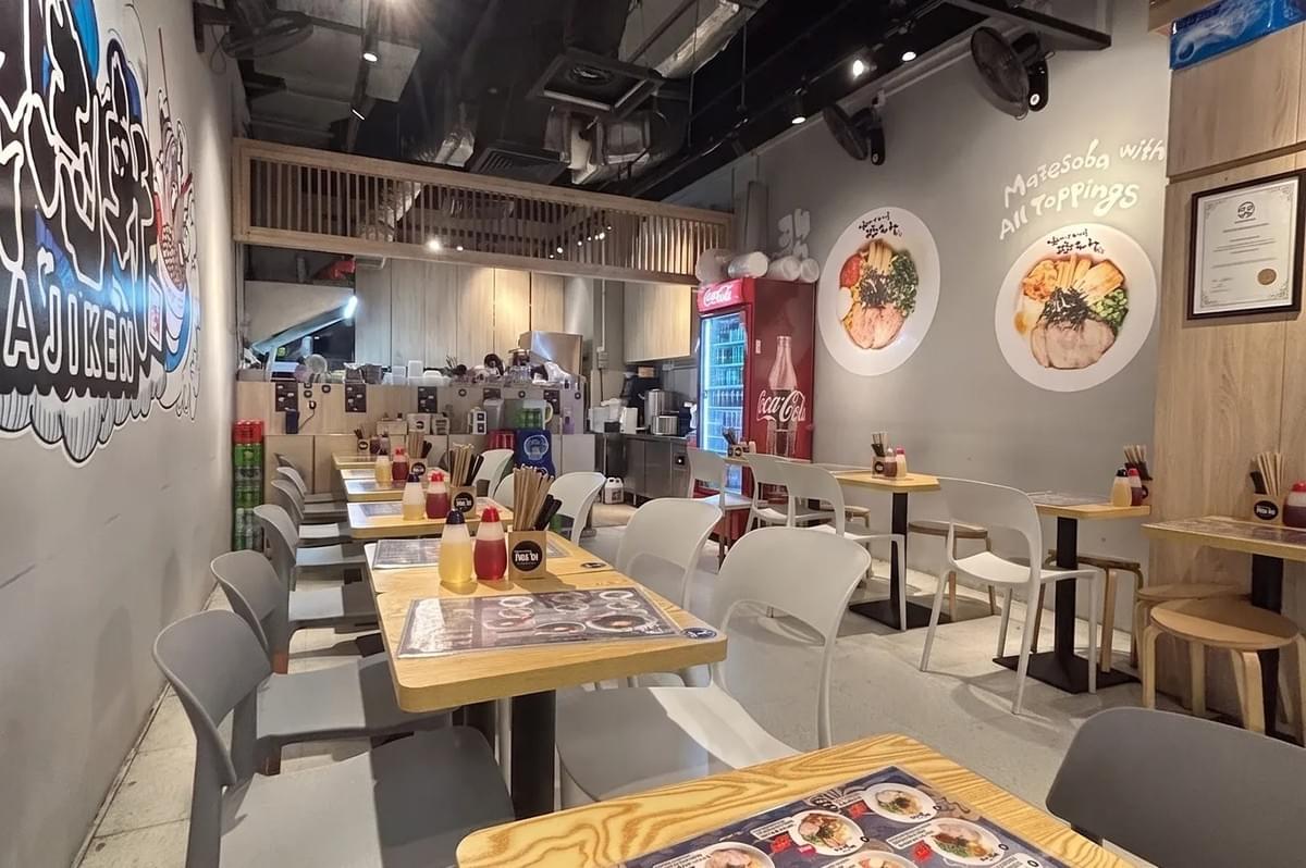 Interior of Hokkaido Ramen Chicken Paitan Haven restaurant in Paya Lebar with wooden tables and white chairs. Interior of Hokkaido Ramen Chicken Paitan Haven restaurant in Paya Lebar with wooden tables and white chairs.