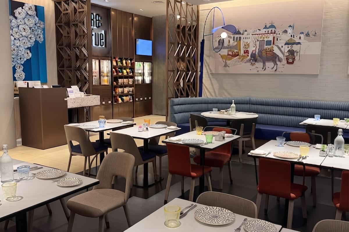 Modern restaurant interior at 21 on Rajah with contemporary dining tables, chairs, and Mediterranean-inspired wall art. Modern restaurant interior at 21 on Rajah with contemporary dining tables, chairs, and Mediterranean-inspired wall art.