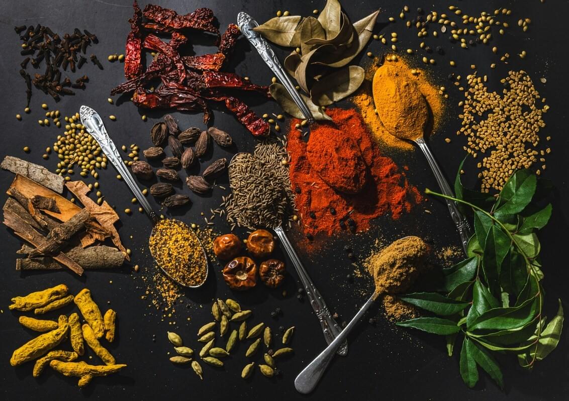 A wooden spoon holding a rich blend of colourful ground spices, showcasing the aromatic foundations of traditional Southeast Asian cuisine. A wooden spoon holding a rich blend of colourful ground spices, showcasing the aromatic foundations of traditional Southeast Asian cuisine.