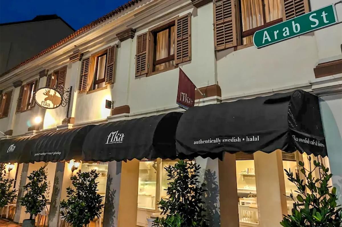 Fika Swedish Cafe and Bistro storefront on Arab Street, featuring black awnings and a moose logo sign. Fika Swedish Cafe and Bistro storefront on Arab Street, featuring black awnings and a moose logo sign.