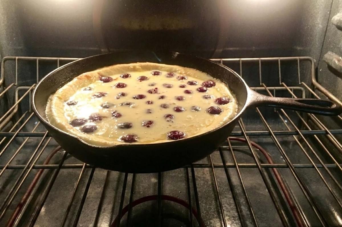 Clafoutis baking in cast iron skillet in oven Clafoutis baking in cast iron skillet in oven