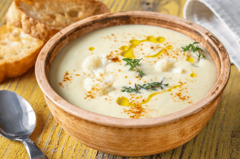 A rustic clay bowl filled with a thick, velvety Velouté sauce garnished with olive oil droplets, fresh thyme, and a dusting of paprika, served alongside toasted bread. A rustic clay bowl filled with a thick, velvety Velouté sauce garnished with olive oil droplets, fresh thyme, and a dusting of paprika, served alongside toasted bread.