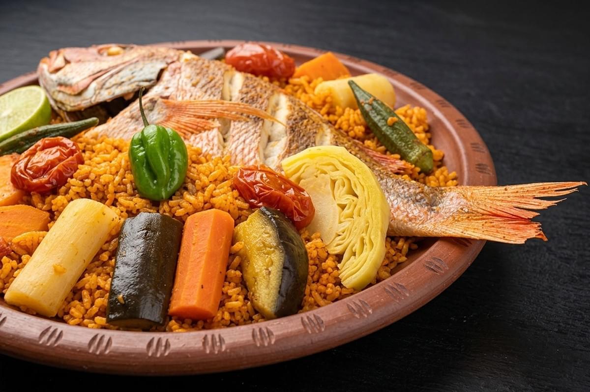 Whole fish on yellow rice with carrots, eggplant, cabbage, and peppers in a clay dish Whole fish on yellow rice with carrots, eggplant, cabbage, and peppers in a clay dish