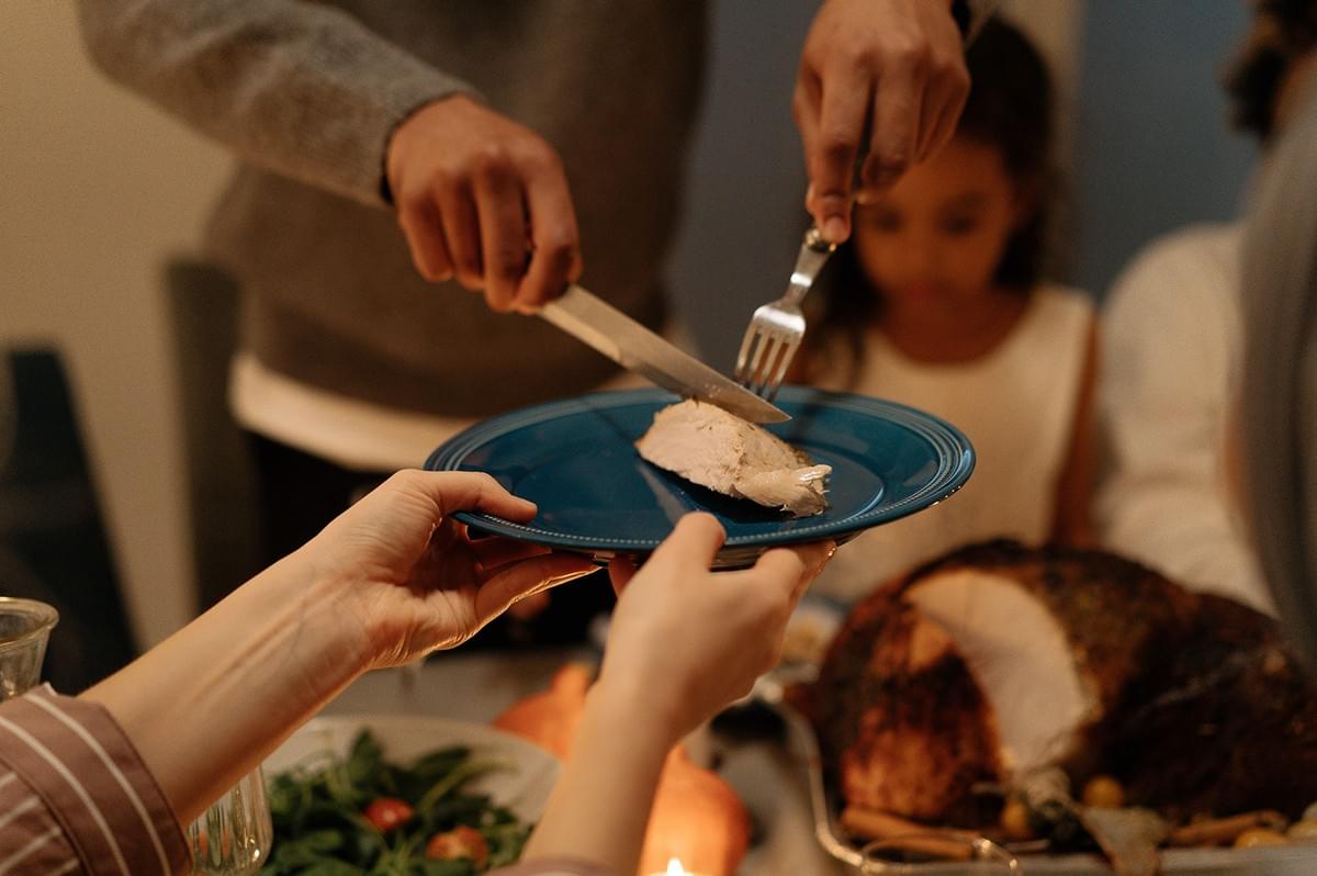 Family sharing a meal and serving food at a dinner table. Family sharing a meal and serving food at a dinner table.