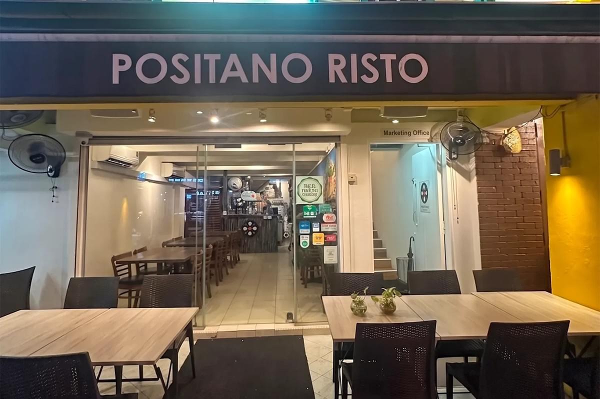 The storefront of Positano Risto, an Italian restaurant featuring outdoor and indoor dining seating, glass doors, and warm ambient lighting. The storefront of Positano Risto, an Italian restaurant featuring outdoor and indoor dining seating, glass doors, and warm ambient lighting.