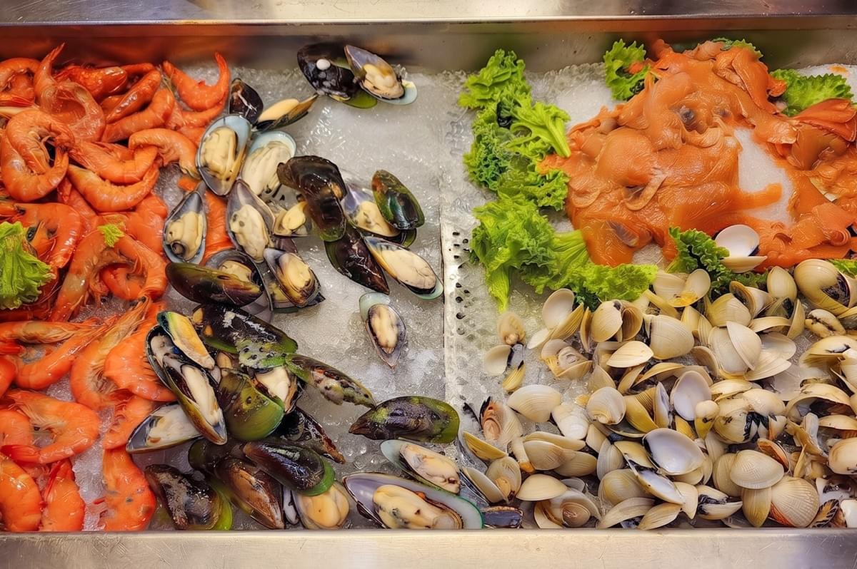 Fresh seafood display featuring prawns, mussels, and clams for East Coast Malaysian cuisine. Fresh seafood display featuring prawns, mussels, and clams for East Coast Malaysian cuisine.
