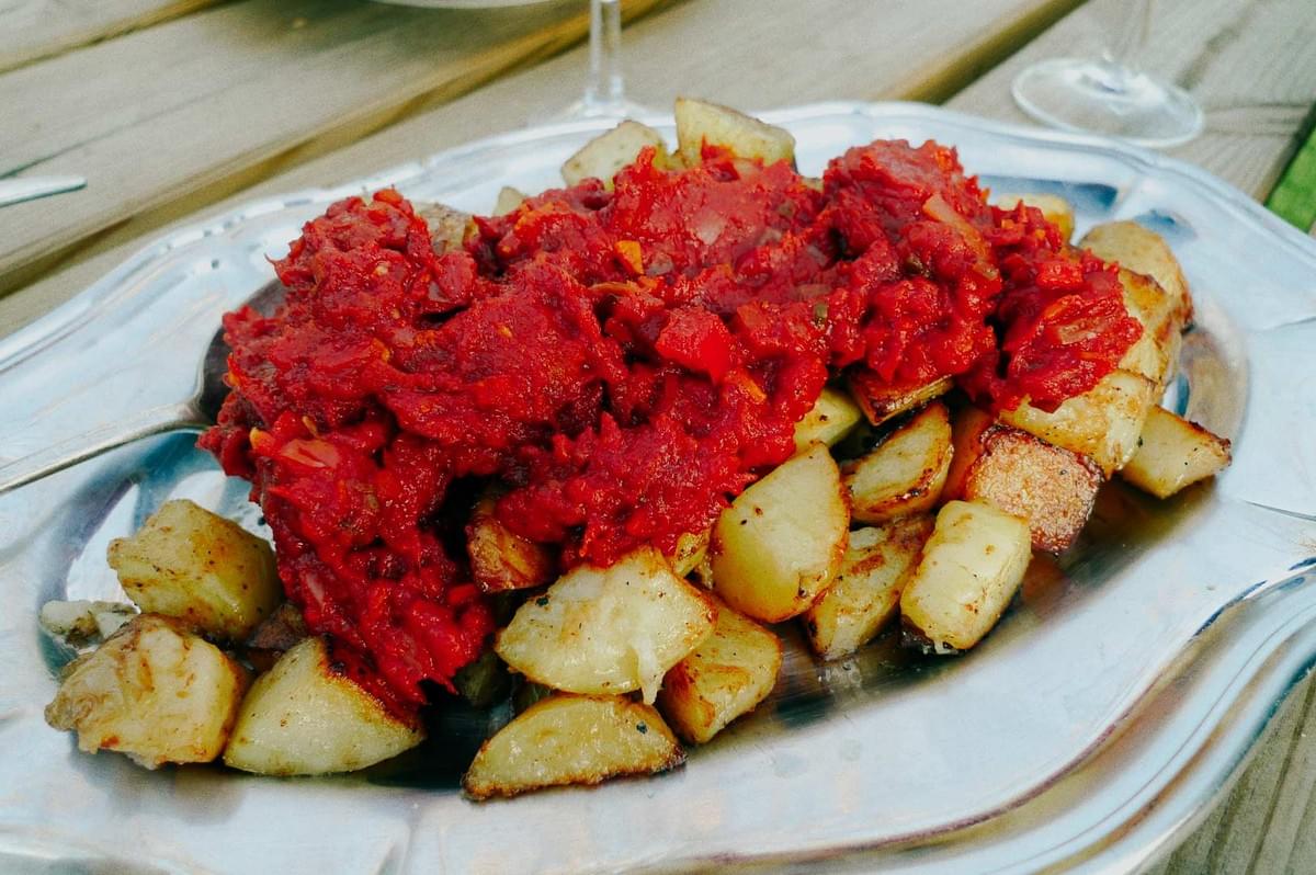 Patatas bravas — golden fried potatoes topped with spicy tomato sauce. Patatas bravas — golden fried potatoes topped with spicy tomato sauce.