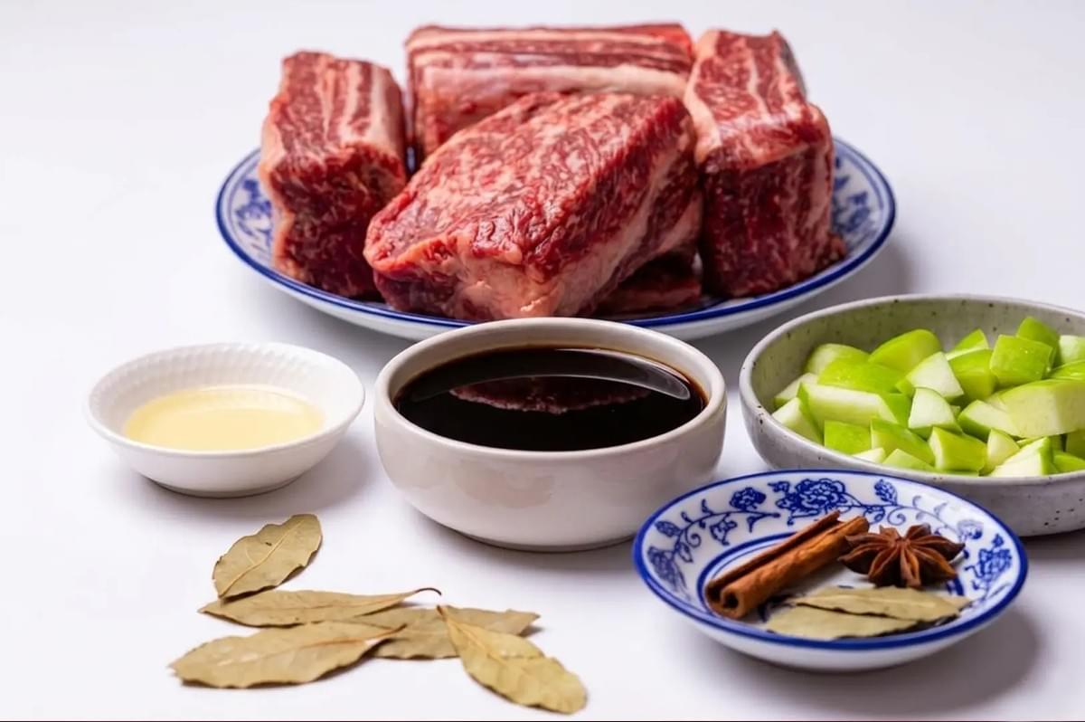 Raw beef ribs and aromatics like soy sauce, star anise, and cinnamon prepared for making soup broth Raw beef ribs and aromatics like soy sauce, star anise, and cinnamon prepared for making soup broth