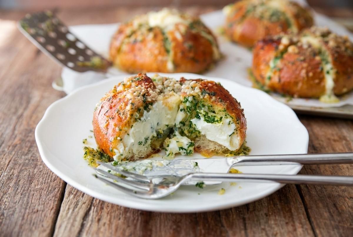 Korean cream cheese garlic bread cut open on a plate with cutlery. Korean cream cheese garlic bread cut open on a plate with cutlery.