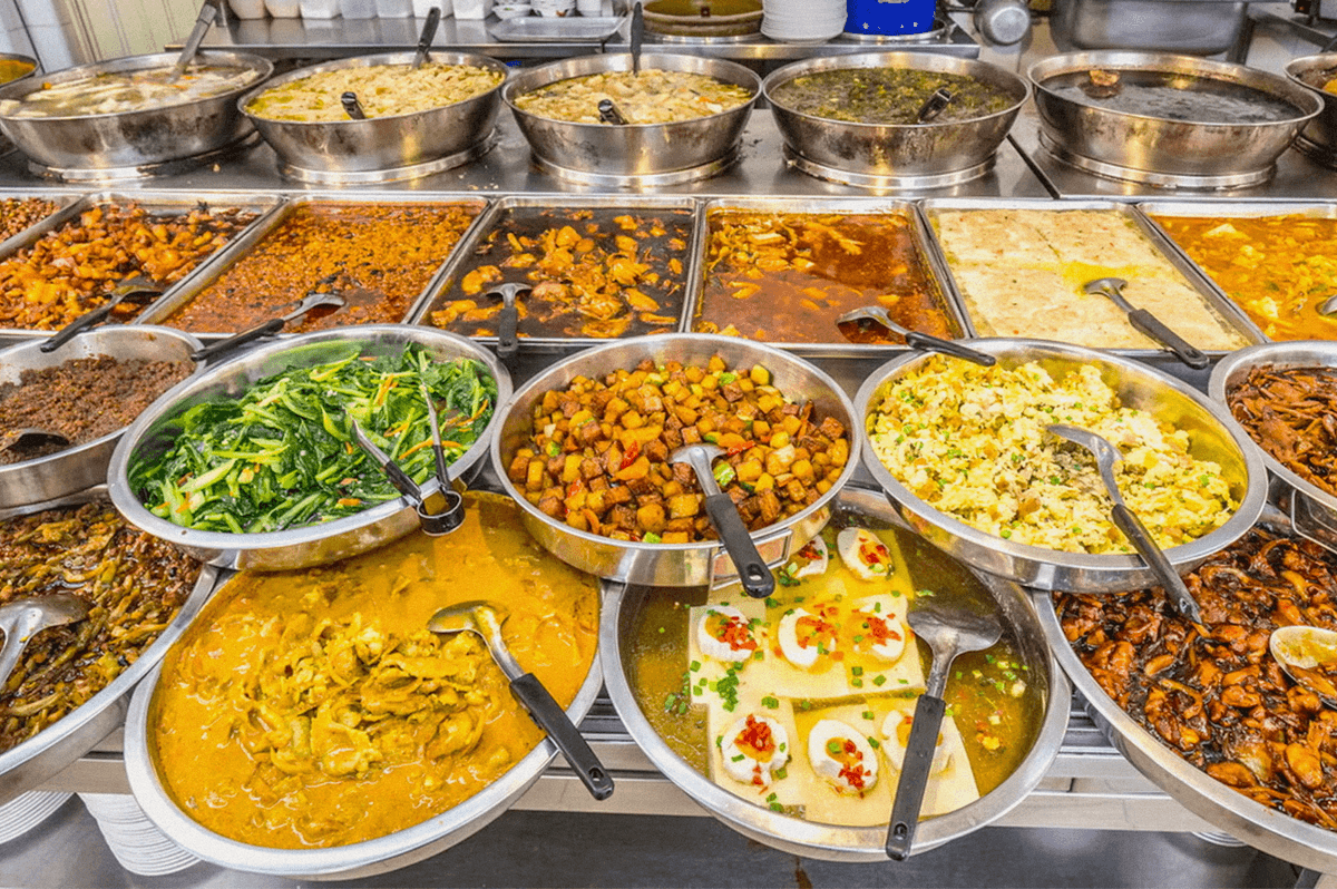 A buffet display featuring a variety of curries, vegetables, noodles, rice, and other Asian dishes. A buffet display featuring a variety of curries, vegetables, noodles, rice, and other Asian dishes.