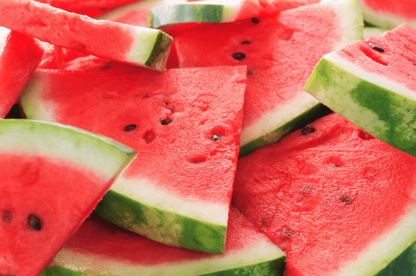 A vibrant pile of triangular watermelon slices with bright red flesh and black seeds, showing off their crisp texture. A vibrant pile of triangular watermelon slices with bright red flesh and black seeds, showing off their crisp texture.