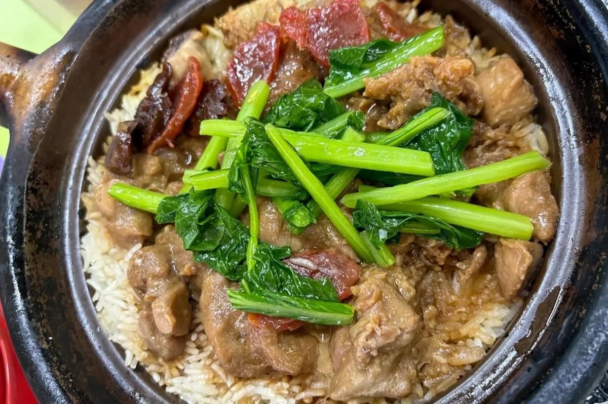 Traditional Chinese claypot chicken rice topped with lap cheong (Chinese sausage) and green vegetables. Traditional Chinese claypot chicken rice topped with lap cheong (Chinese sausage) and green vegetables.