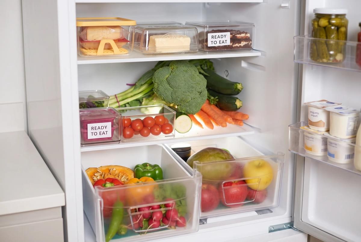Well-organized refrigerator interior with labeled "Ready to Eat" containers, fresh vegetables, and crisp drawers. Well-organized refrigerator interior with labeled "Ready to Eat" containers, fresh vegetables, and crisp drawers.