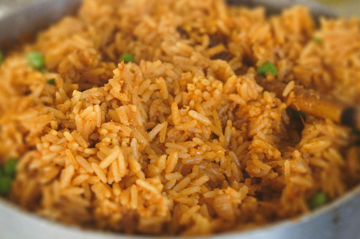 Close-up of freshly cooked coconut jollof rice in a pot. Close-up of freshly cooked coconut jollof rice in a pot.