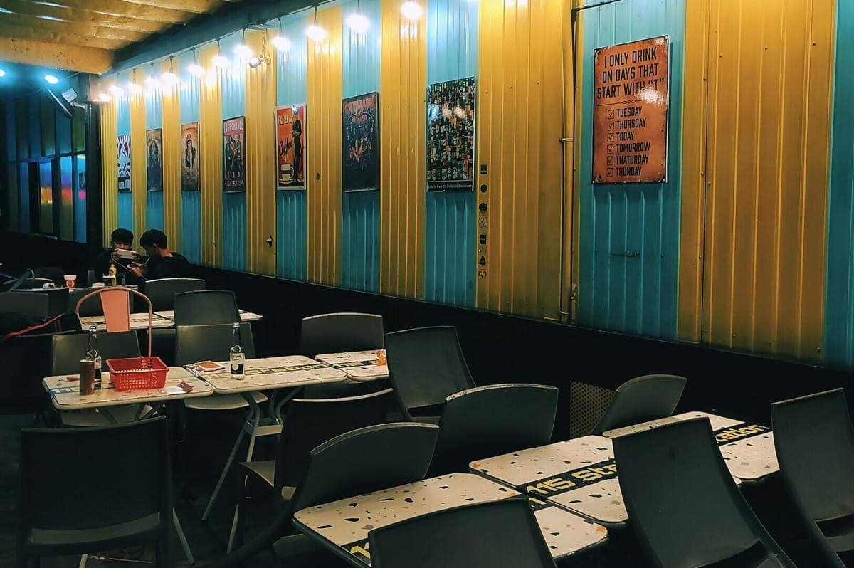 A fusion restaurant in Singapore featuring tables and chairs arranged in front of a decorative wall. A fusion restaurant in Singapore featuring tables and chairs arranged in front of a decorative wall.