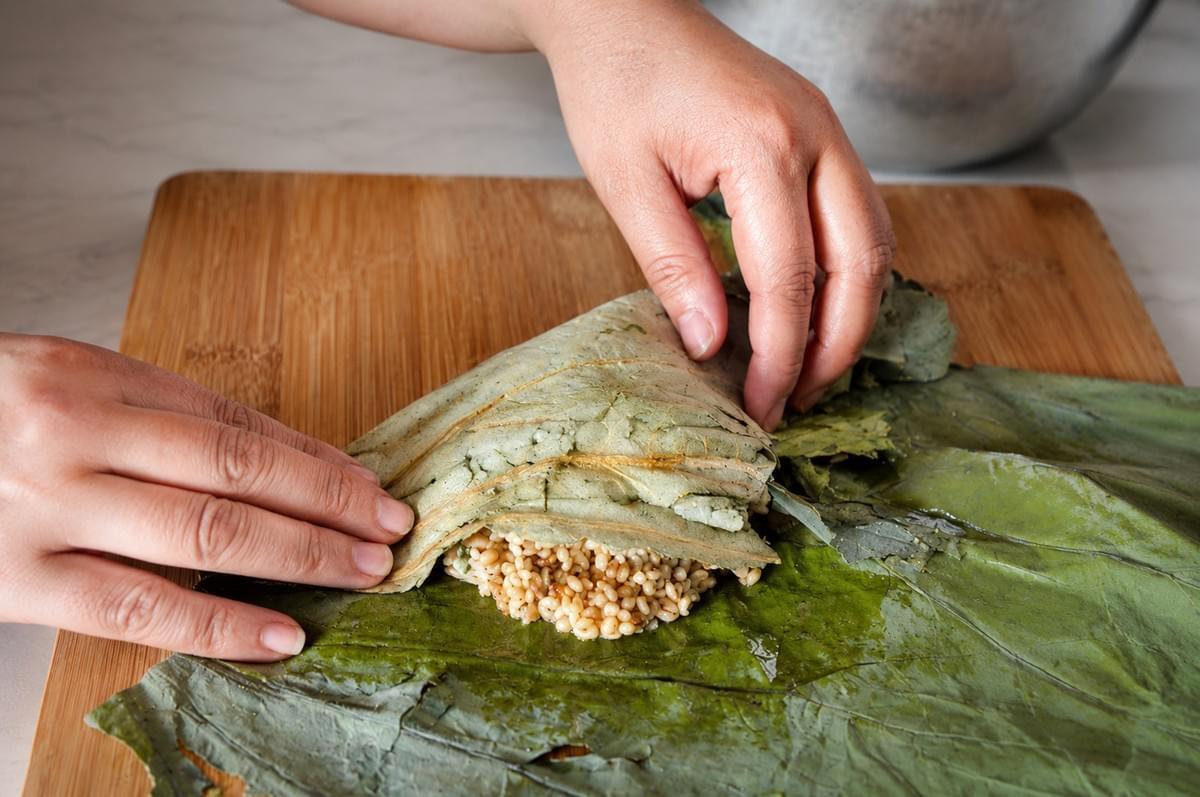 Lotus leaf sticky rice comes from **Cantonese cooking, where it shows up on dim sum tables and family stoves alike.** The everyday dim sum version, lo mai gai, tucks glutinous rice and a chicken filling into a lotus leaf, then steams it until everything melts together. Why the lotus leaf? It is not just for looks. As the parcel steams, **the leaf gives off a gentle, earthy fragrance that soaks right into the rice**. It also holds everything in a tidy bundle and keeps the rice moist. No leaf, no magic. That aroma is the whole soul of the dish. The filling changes from kitchen to kitchen. Some keep it simple. Others add dried shrimp, salted egg, or a spoon of the braising liquid. This is a home cook's version, friendly for beginners, easy to make your own. ## Before You Start - **Prep time:** 30 minutes (plus soaking) - **Cook time:** 1 hour steaming - **Servings:** 4 parcels - **Difficulty:** Easy to moderate (the wrapping takes a little practice, and that is okay) Most of the work here is waiting. The rice needs a good soak, and the parcels need a long, slow steam. Hands-on time is short. ## Ingredients Lotus leaf sticky rice comes from **Cantonese cooking, where it shows up on dim sum tables and family stoves alike.** The everyday dim sum version, lo mai gai, tucks glutinous rice and a chicken filling into a lotus leaf, then steams it until everything melts together. Why the lotus leaf? It is not just for looks. As the parcel steams, **the leaf gives off a gentle, earthy fragrance that soaks right into the rice**. It also holds everything in a tidy bundle and keeps the rice moist. No leaf, no magic. That aroma is the whole soul of the dish. The filling changes from kitchen to kitchen. Some keep it simple. Others add dried shrimp, salted egg, or a spoon of the braising liquid. This is a home cook's version, friendly for beginners, easy to make your own. ## Before You Start - **Prep time:** 30 minutes (plus soaking) - **Cook time:** 1 hour steaming - **Servings:** 4 parcels - **Difficulty:** Easy to moderate (the wrapping takes a little practice, and that is okay) Most of the work here is waiting. The rice needs a good soak, and the parcels need a long, slow steam. Hands-on time is short. ## Ingredients
