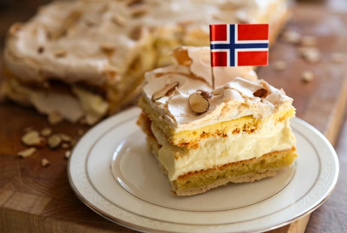 Slice of Kvæfjordkake with a small Norwegian flag toothpick on a white dessert plate. Slice of Kvæfjordkake with a small Norwegian flag toothpick on a white dessert plate.