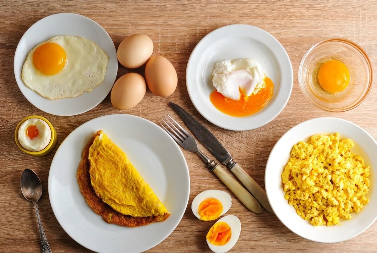 Overhead spread of various egg dishes including poached, scrambled, fried, omelet, and hard-boiled. Overhead spread of various egg dishes including poached, scrambled, fried, omelet, and hard-boiled.