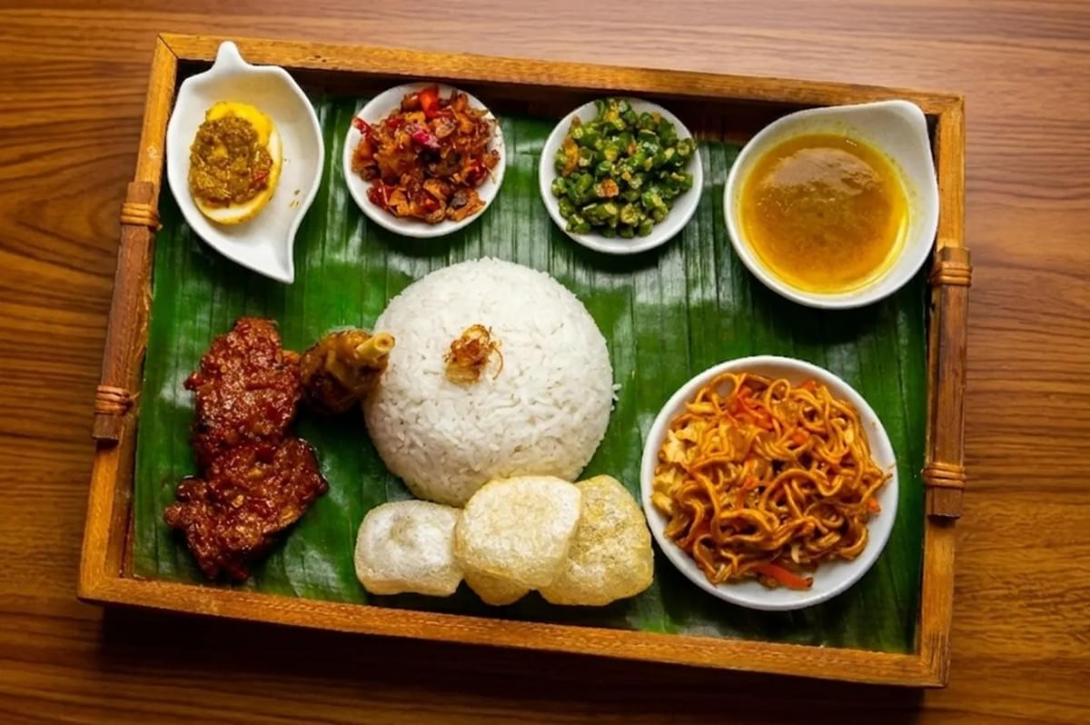 Nasi Campur rice platter served on a banana leaf with beef rendang, sambal egg, stir-fried noodles, and crackers. Nasi Campur rice platter served on a banana leaf with beef rendang, sambal egg, stir-fried noodles, and crackers.