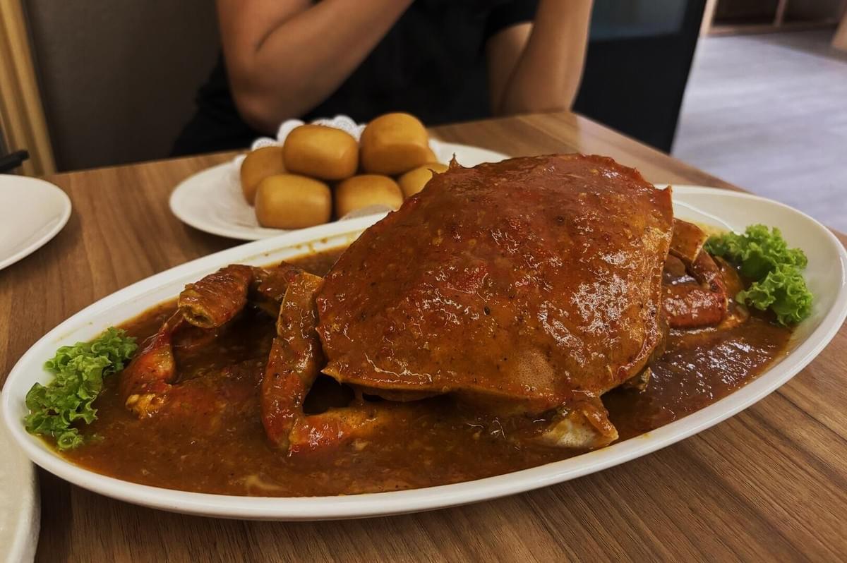 A vibrant chili crab resting on a plate, surrounded by a flavorful sauce, showcasing a delicious seafood dish. A vibrant chili crab resting on a plate, surrounded by a flavorful sauce, showcasing a delicious seafood dish.