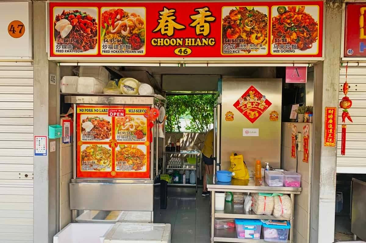 Alt text: "A vibrant street food stall named Choon Hiang featuring colorful menu images of fried noodles and rice. The stall is decorated with bright signage and traditional Chinese ornaments, conveying a lively and inviting atmosphere." Alt text: "A vibrant street food stall named Choon Hiang featuring colorful menu images of fried noodles and rice. The stall is decorated with bright signage and traditional Chinese ornaments, conveying a lively and inviting atmosphere."