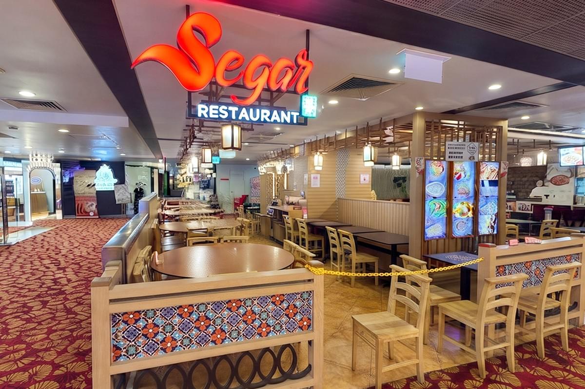 Exterior view of Segar Restaurant storefront with indoor dining seating and wooden furniture inside a shopping mall. Exterior view of Segar Restaurant storefront with indoor dining seating and wooden furniture inside a shopping mall.