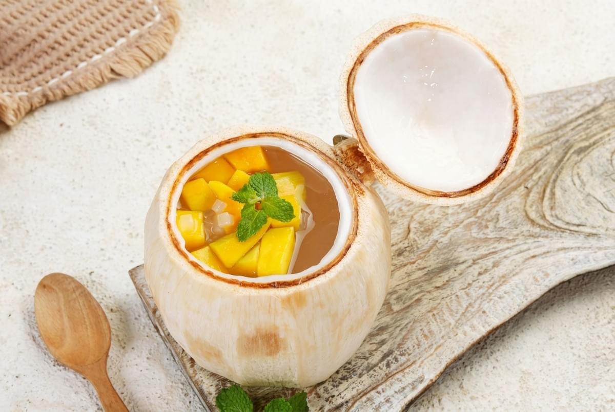 Fresh young coconut filled with coconut jelly and diced mangoes, topped with a mint garnish. Fresh young coconut filled with coconut jelly and diced mangoes, topped with a mint garnish.