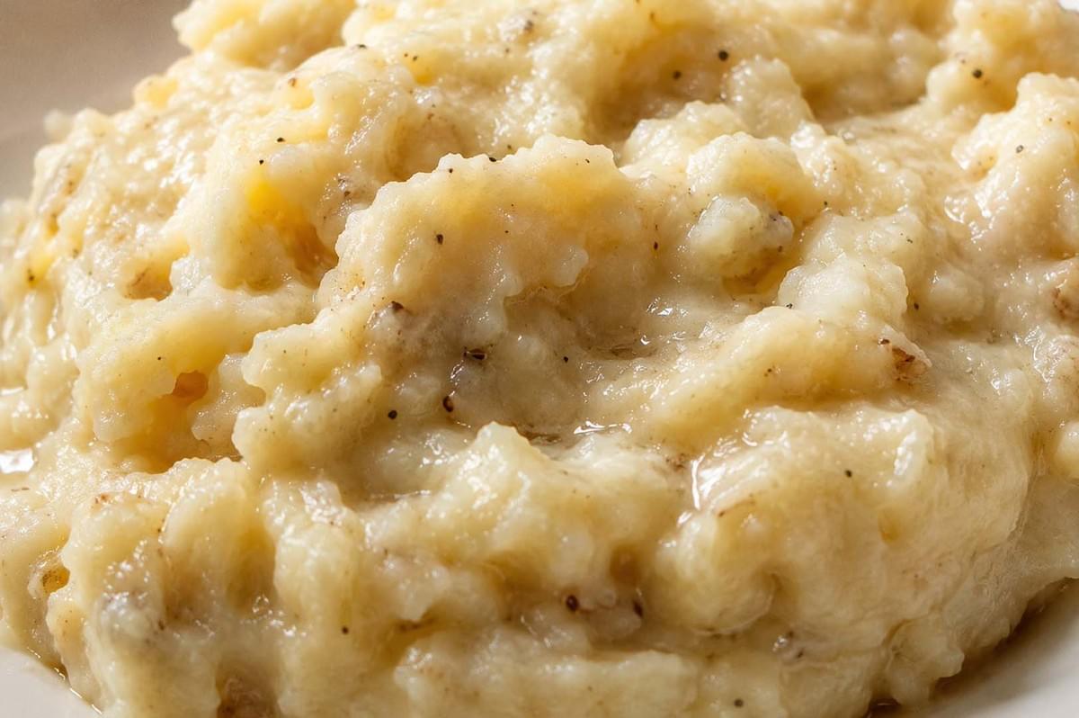 Close-up texture of creamy plokkfiskur showing the mashed fish and potato consistency with black pepper specks Close-up texture of creamy plokkfiskur showing the mashed fish and potato consistency with black pepper specks