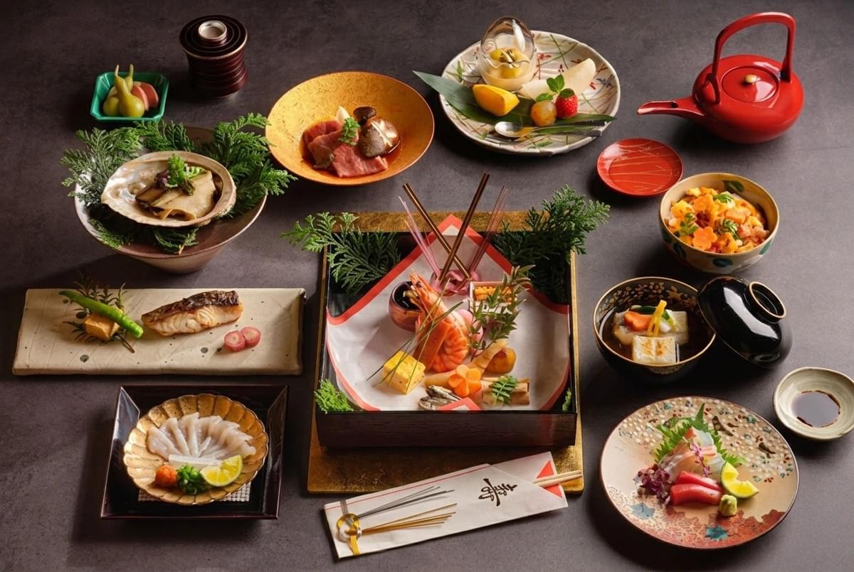 Elegant multi-course Japanese kaiseki meal arranged on small decorative dishes and lacquerware. Elegant multi-course Japanese kaiseki meal arranged on small decorative dishes and lacquerware.