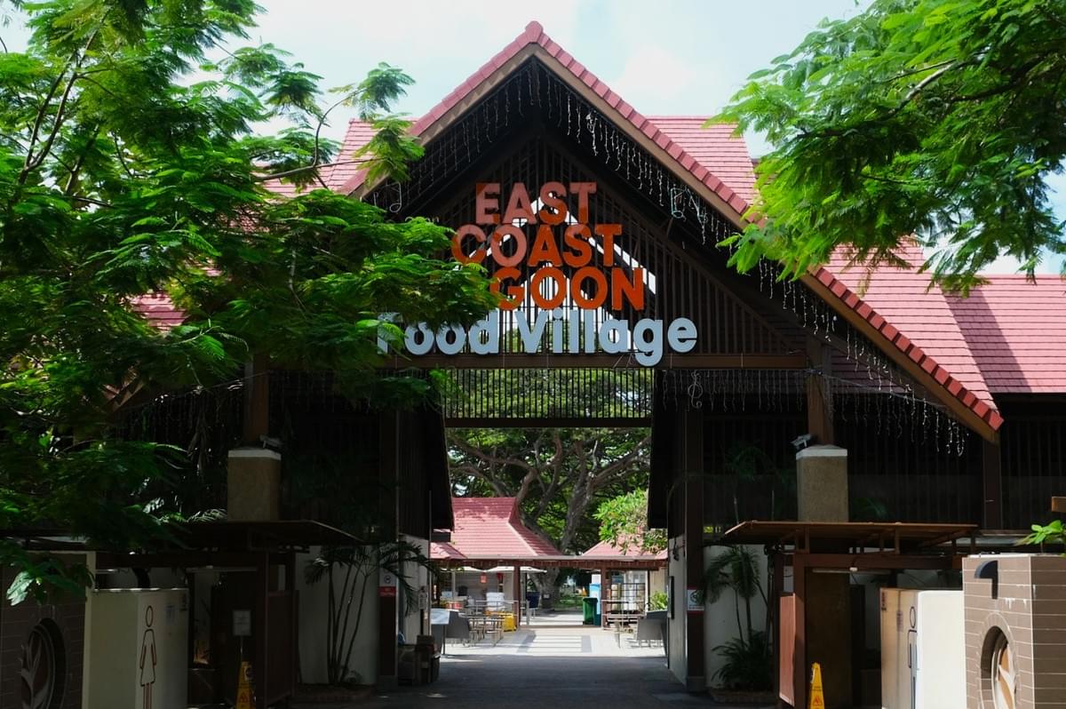 Entrance to East Coast Lagoon Food Village with red-tiled roof and lush green trees surrounding it. The scene is inviting and vibrant. Entrance to East Coast Lagoon Food Village with red-tiled roof and lush green trees surrounding it. The scene is inviting and vibrant.