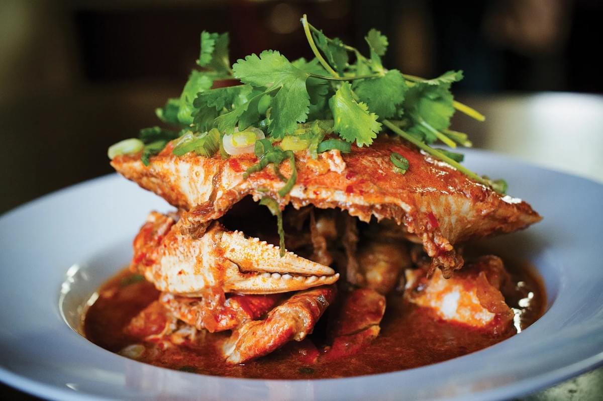 A serving of chili crab, showcasing tender crab meat drizzled with a flavorful sauce. A serving of chili crab, showcasing tender crab meat drizzled with a flavorful sauce.