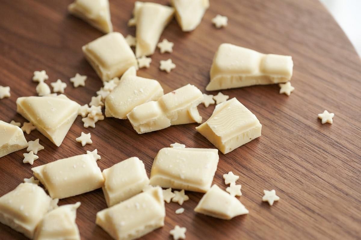 White chocolate chunks and cocoa butter on a wooden board. White chocolate chunks and cocoa butter on a wooden board.