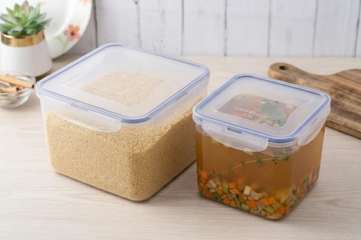 Clear storage containers holding dry couscous grains and vegetable broth with chopped vegetables Clear storage containers holding dry couscous grains and vegetable broth with chopped vegetables