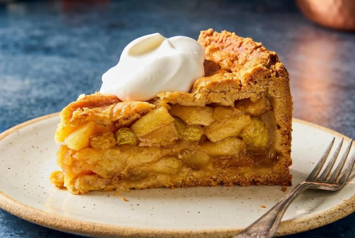Deep-dish apple pie with a golden lattice top set on a marble serving board. Deep-dish apple pie with a golden lattice top set on a marble serving board.